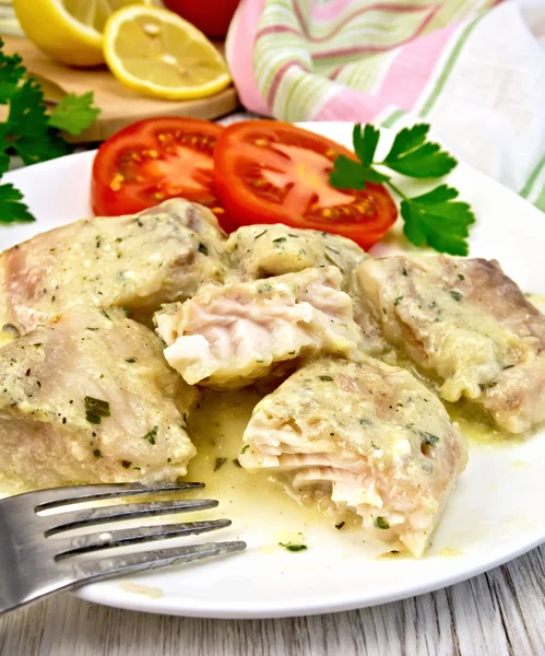 Vis stoofpot met tomaten in plaat aan boord in roomsaus — Stockfoto