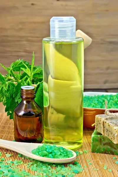 Shampoo and toiletries with nettles on board — Stock Photo, Image