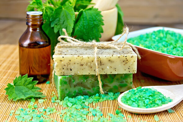 Soap homemade and oil with nettles in mortar on board