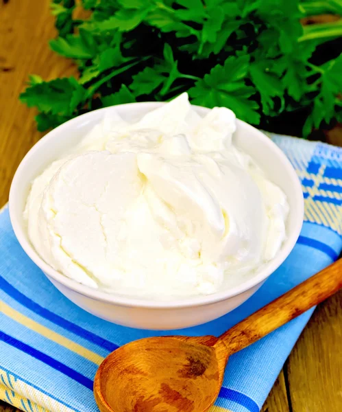 Yogourt dans un bol blanc avec des légumes verts à bord — Photo