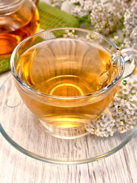 Tea with yarrow in glass cup on board Stock Photo