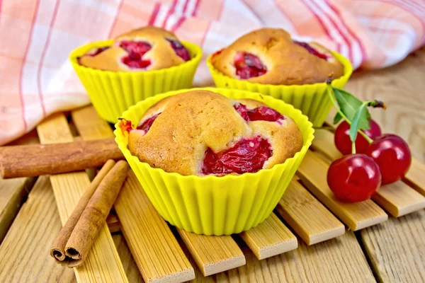 Cupcakes with cherries in tins on board — Stock Photo, Image