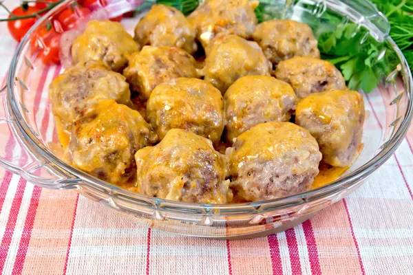 Meatballs with sauce in glass pan on linen tablecloth — Stock Photo, Image