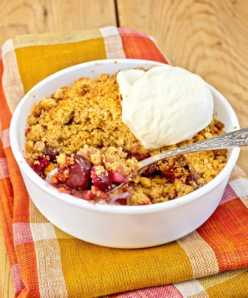 Crumble cherry in bowl with ice cream on board — Stock Photo, Image