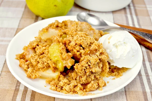 Crumble with pears in plate on tablecloth — Stock Photo, Image