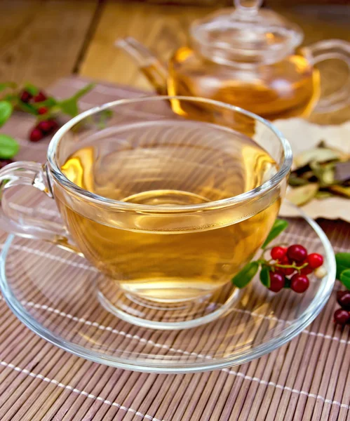 Чай с брусникой в стеклянной чашке на бамбуковой салфетке — стоковое фото