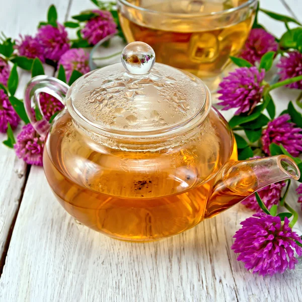 Tea with clover in glass teapot on board — Stock Photo, Image