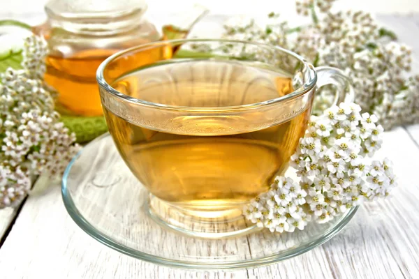 Tea with yarrow in cup on light board — Stock Photo, Image