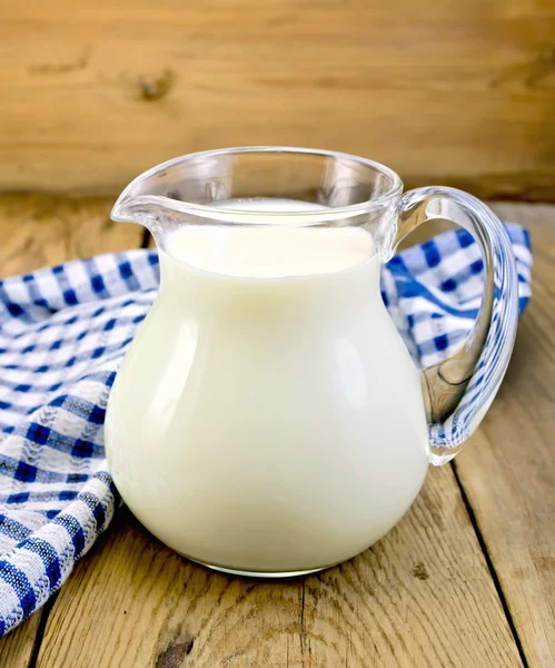 Mleko w Dzbanek szklany z serwetka na pokładzie — Zdjęcie stockowe