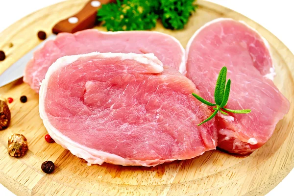 Meat pork slices with rosemary on round board — Stock Photo, Image