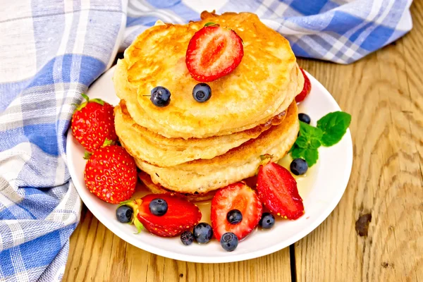Flapjacks with strawberries and blueberries on board — Stock Photo, Image