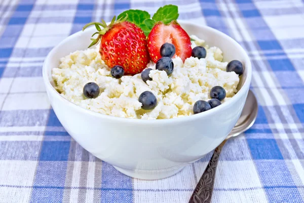 Curd in bowl with strawberries and blueberries on tablecloth — Stock Photo, Image