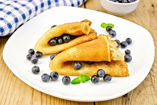 Pancakes with blueberries on wooden board — Stock Photo, Image