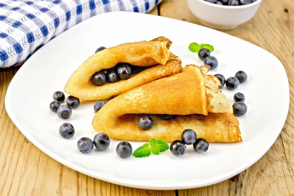 Pannkakor med blåbär på träskiva — Stockfoto