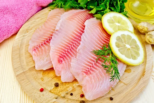 Tilapia con aceite y limón sobre tabla ligera — Foto de Stock