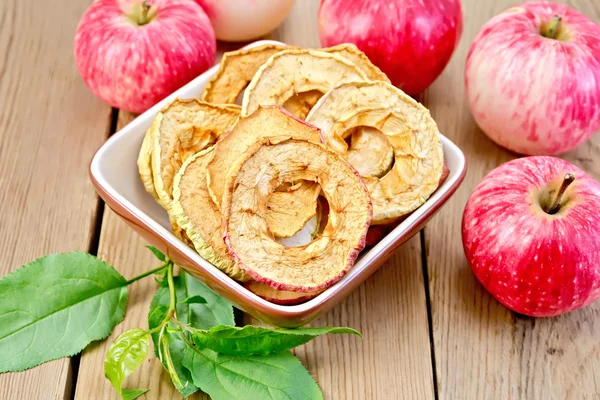 Apples fresh and dried in bowl on board with sheet — Stock Photo, Image