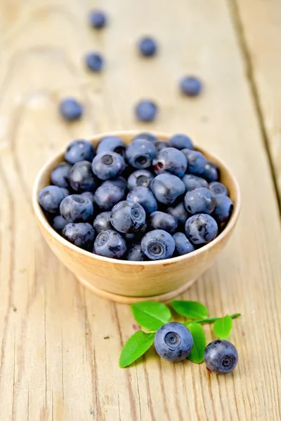 Blueberries in wooden bowl on board — Stock Photo, Image