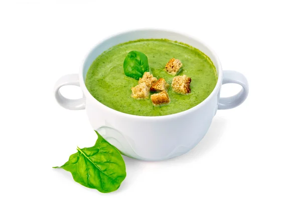 Суп пюре с гренками и листья шпината в миске — стоковое фото