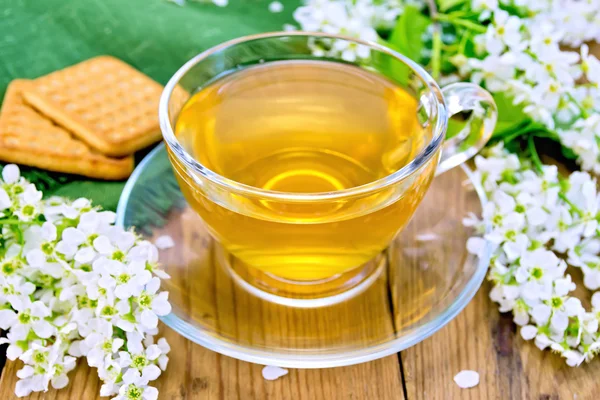 Tea in cup with cookies and flowers of bird cherry on board — Stock Photo, Image