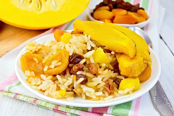 Pilaf fruit with pumpkin in white plate on board — Stock Photo, Image