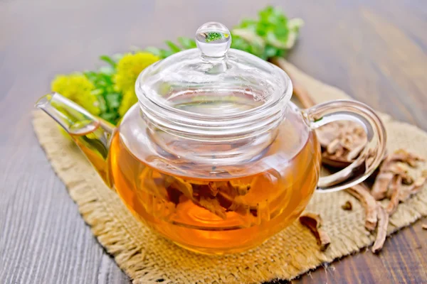 Tea of Rhodiola rosea in glass teapot on board — Stock Photo, Image