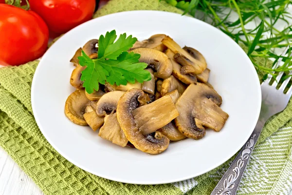 Champignons fried in plate with parsley on light board — Stock Photo, Image