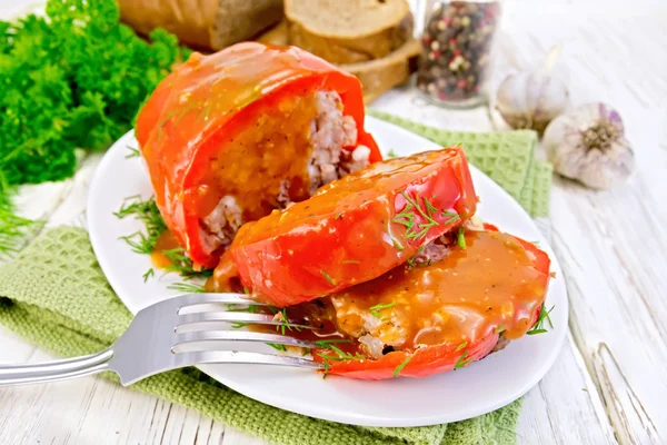 Pepper stuffed meat with sauce and fork in plate on table — Stock Photo, Image