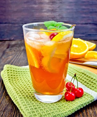 Lemonade with cherry in glassful on dark board