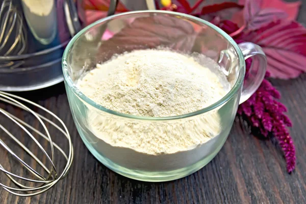 Flour amaranth in glass cup with sieve on board — Stock fotografie