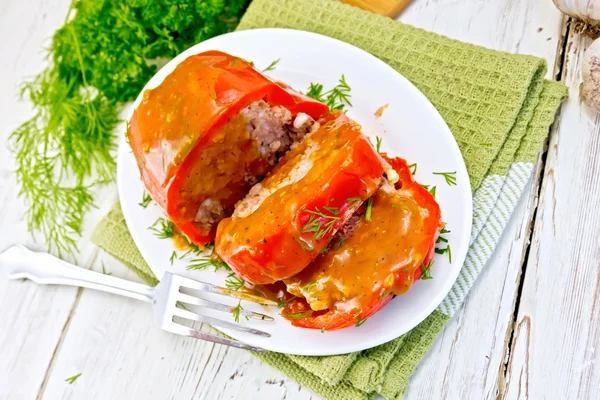 Перец фаршированное мясо с соусом в тарелке на столе — стоковое фото