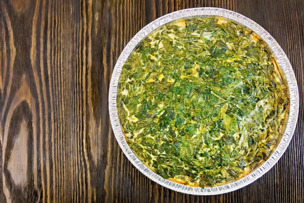 Pie celtic with spinach in form of foil on table — 스톡 사진
