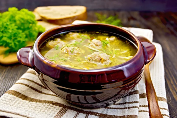 Soup with meatballs and noodles in pottery on board — Stock Photo, Image