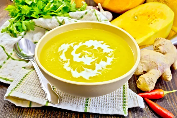 Soup-puree pumpkin with cream in bowl on napkin and board — Stok fotoğraf