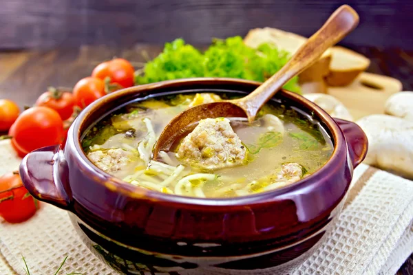 Soup with meatballs and spoon in pottery on board — Stock Image Soup with meatballs and spoon in pottery on board Stock Image