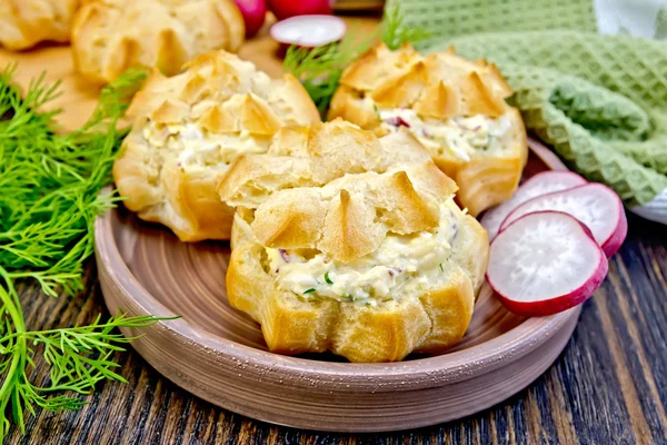 Appetizer of radish and cheese in profiteroles on clay plate — Stock fotografie