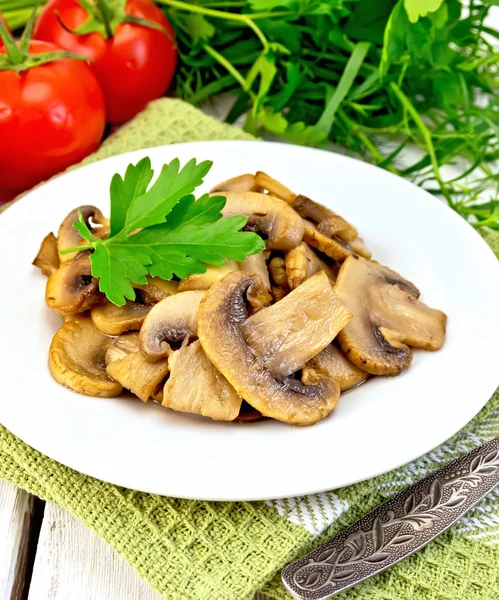 Champignons fried in plate with fork on light board — Stock Photo, Image