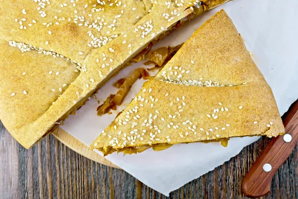 Pie with cabbage and sesame on parchment top — Stock Photo, Image