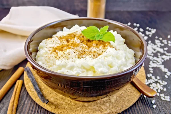 Rice porridge with cinnamon in bowl on board — Zdjęcie stockowe