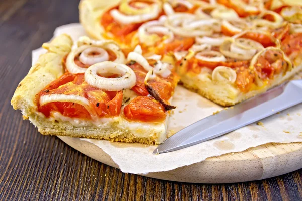 Pie with onions and tomatoes on parchment — Stock Photo, Image
