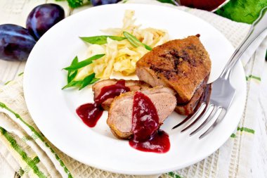 Duck breast with plum sauce and green onions in plate on napkin