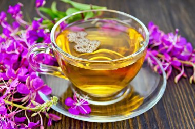 Tea from fireweed in glass cup on dark board