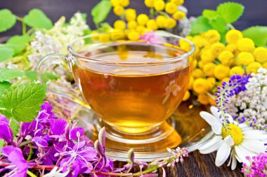 Tea from flowers in glass cup on board