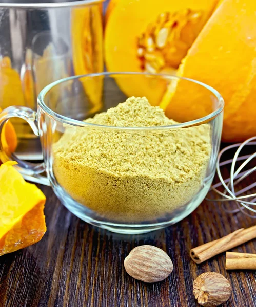Flour pumpkin in glass cup with sieve and cinnamon on board — Stockfoto