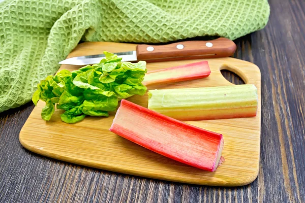 Rhubarb with knife and napkin on board — Stockfoto