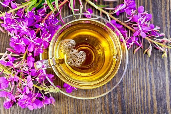 Tea from fireweed in glass cup on board top — Stockfoto