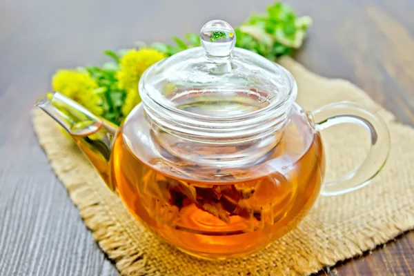 Tea of Rhodiola rosea in glass teapot on sacking — Stockfoto