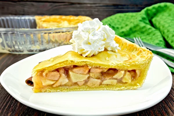 Pie apple with whipped cream in plate on board — Stock Photo, Image
