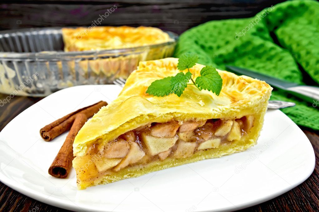 Pie apple with mint in plate on dark board