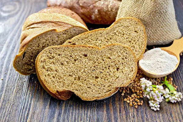 Pão de trigo sarraceno com cereais e flor na placa escura — Fotografia de Stock