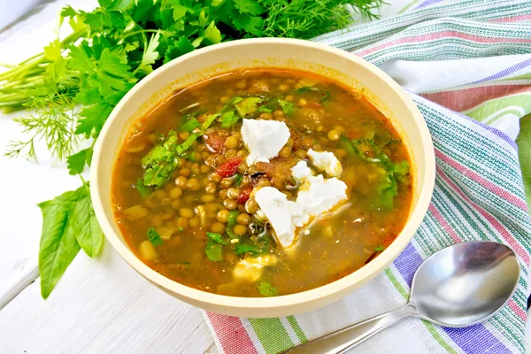 Suppenlinsen mit Spinat und Käse in gelber Schüssel an Bord — Stockfoto